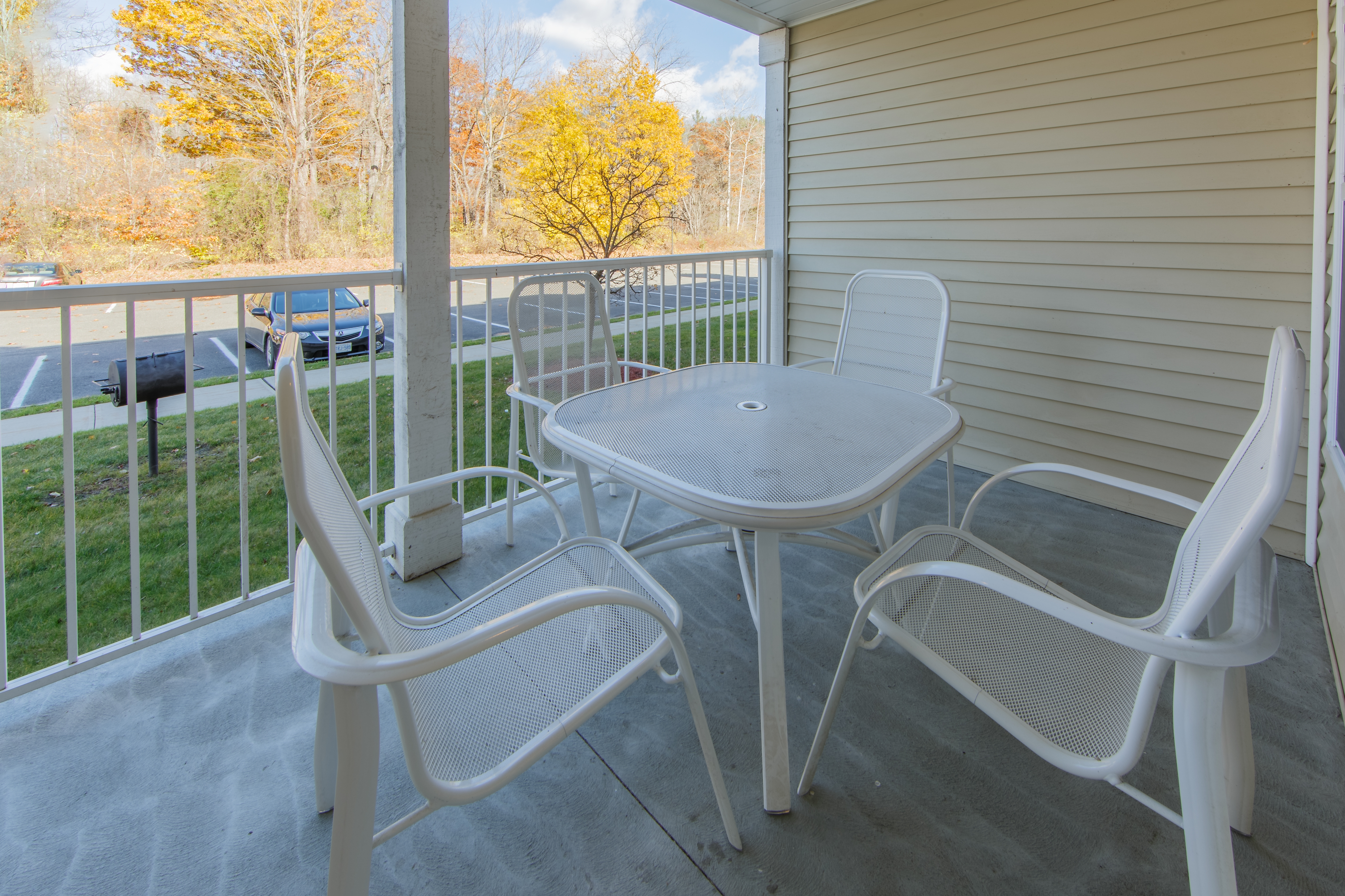 Patio overlooking trees and a parking lot in a villa at Oak n' Spruce Resort in South Lee, Massachusetts