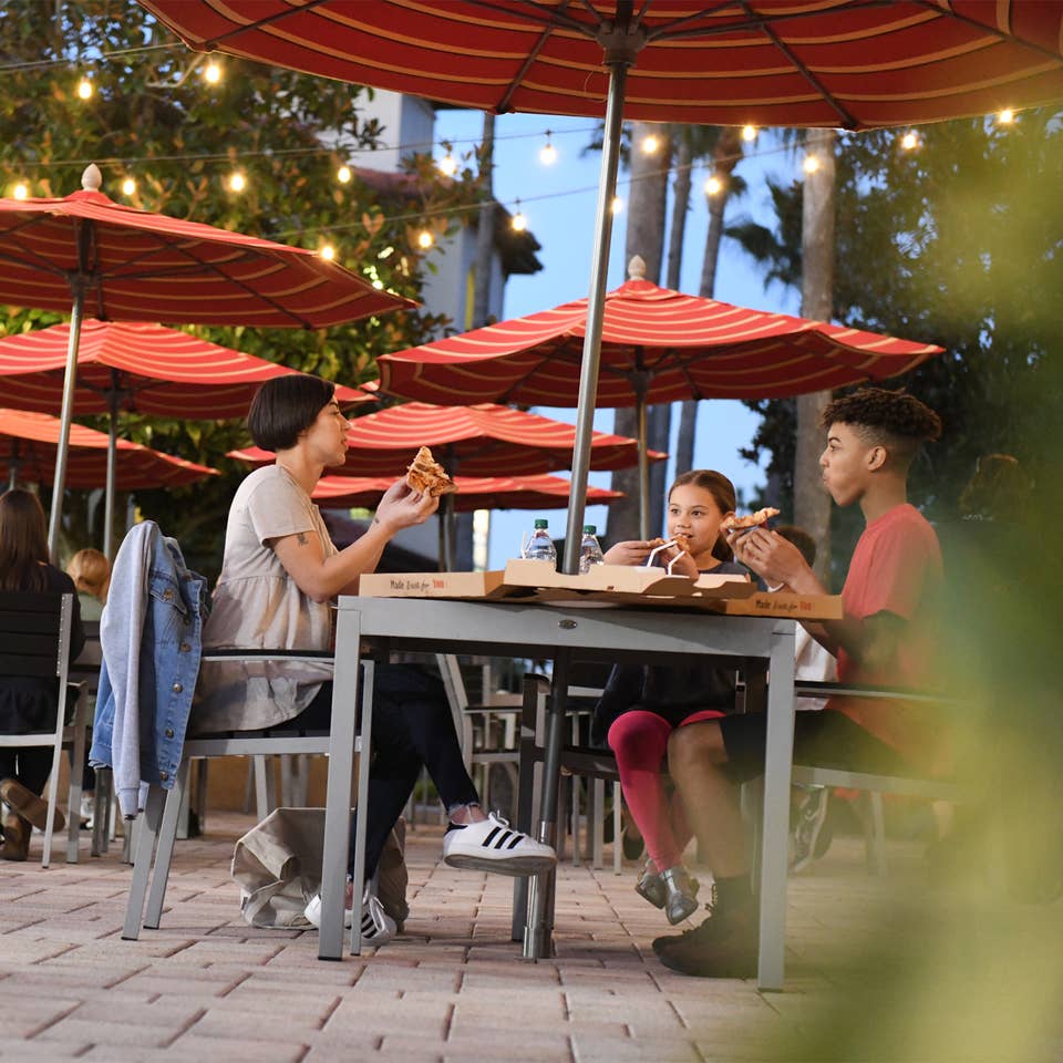 A group of people eating outside of Paisan Pizzeria at Orange Lake Resort near Orlando, Florida.