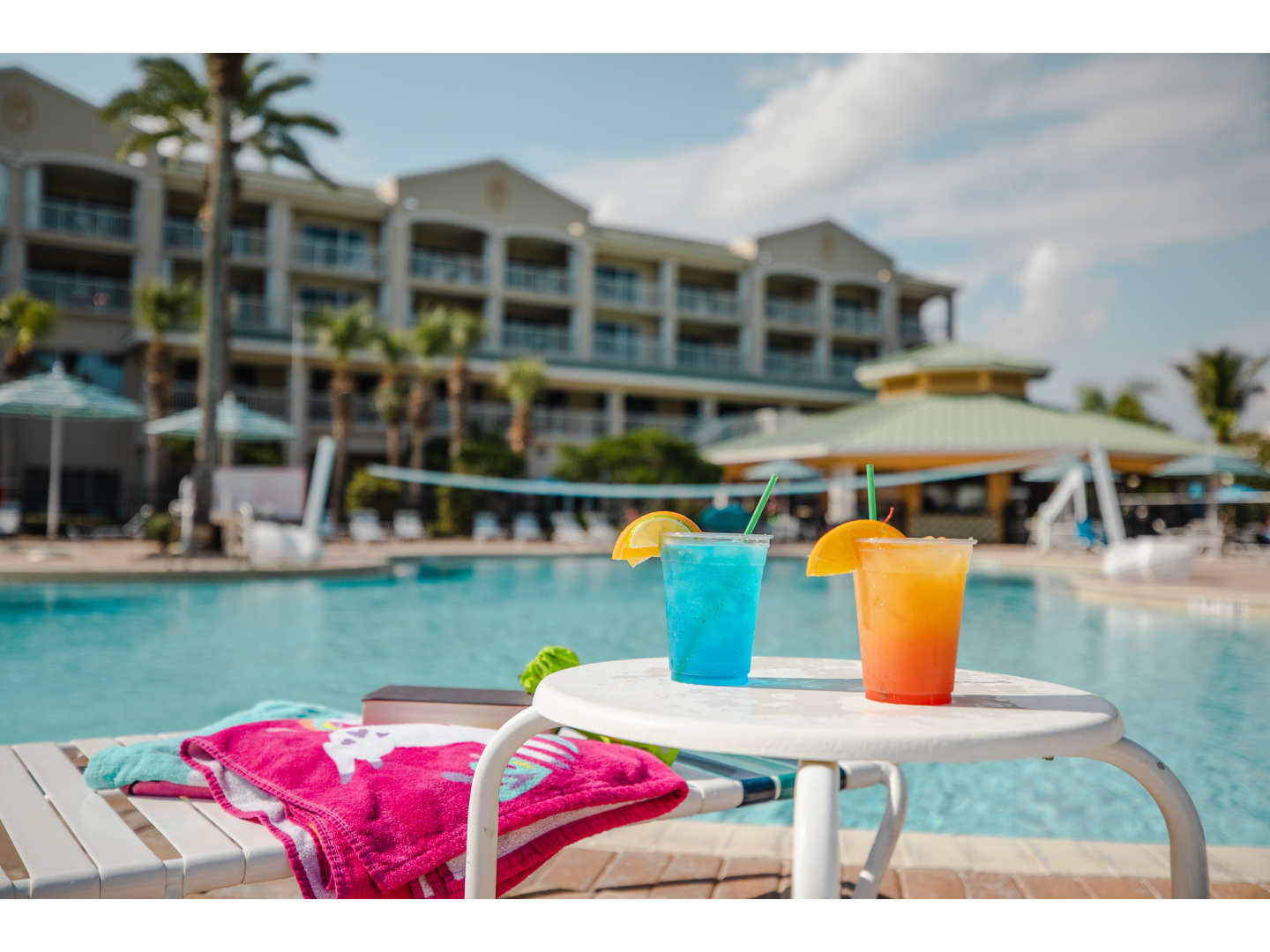 Tropical drinks sit in front of resort pool.