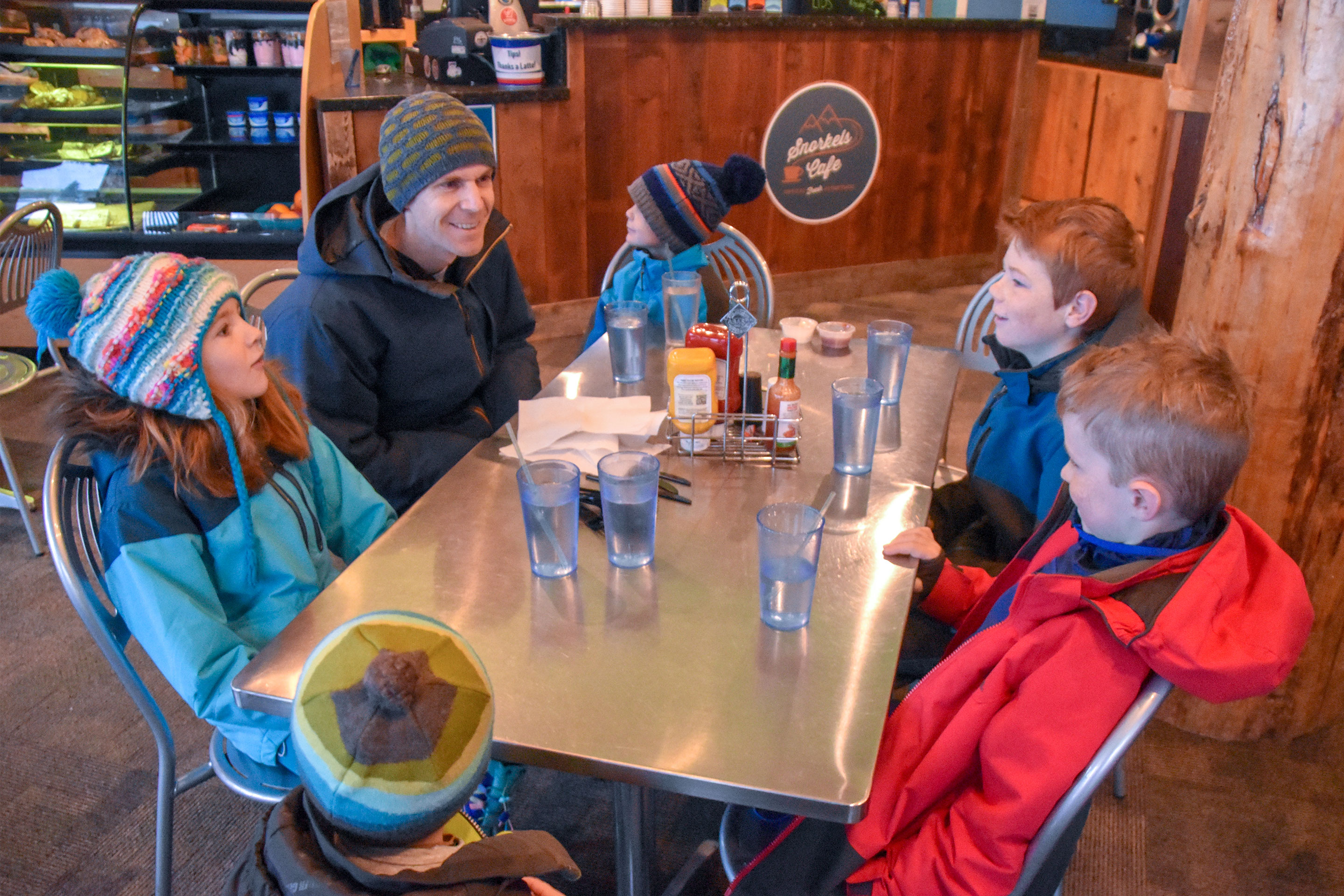 Jessica's family gathers around the cafeteria table with glasses of water.
