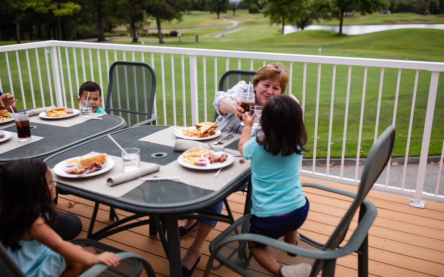 Family eating outdoors at The Grille on the Greens at Holiday Hills Resort in Branson, Missouri.