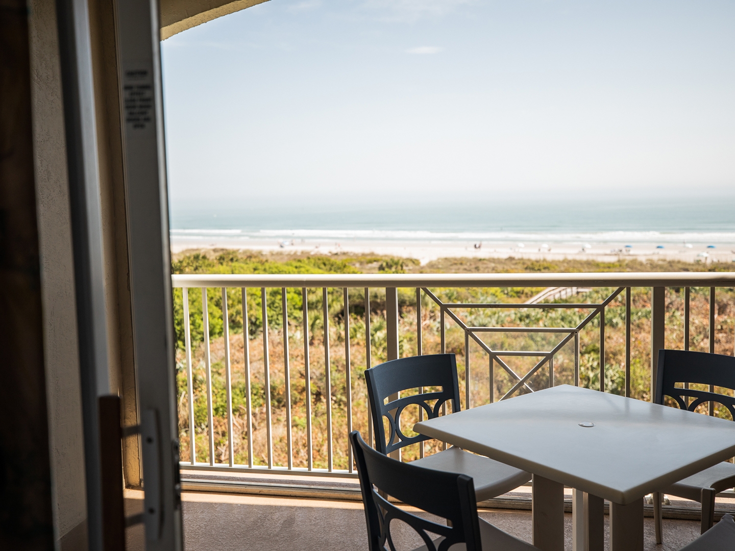 Balcony with table and chairs in a two-bedroom villa at Cape Canaveral Beach Resort.