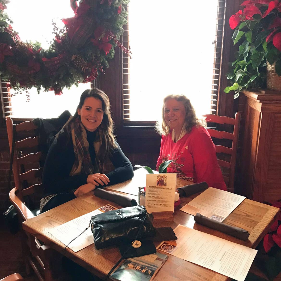 Author, Jenn C. Harmon (left), and her mother-in-law (right) seated near a table in front of a window while dining at the Stable Cafe.