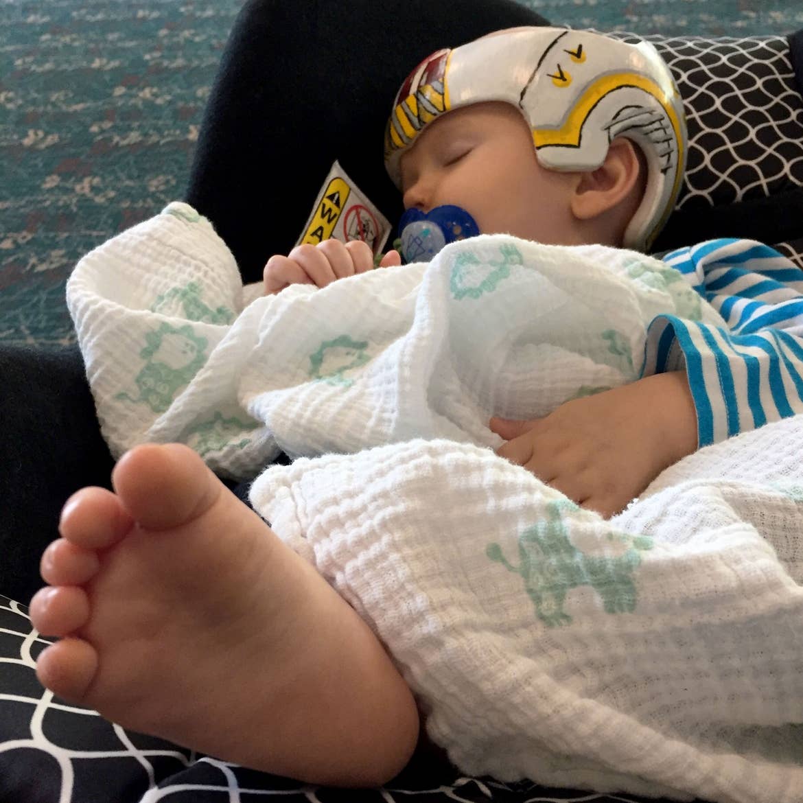 Sarah's son, Logan, sits bundled in his car seat as they await to board the airplane.