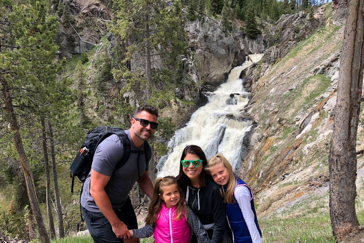 Author, Chris Johnston (middle-right), stands in front of the Mystic Falls at Yellowstone National Park with her husband, Josh (far-left), and daughters, Kyndall (far-right), and Kyler (middle-left).