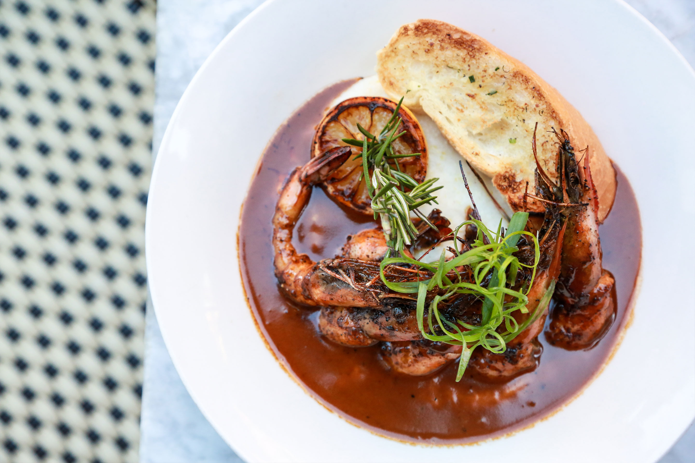 A white plate containing Shrimp and Grits from Tableau.
