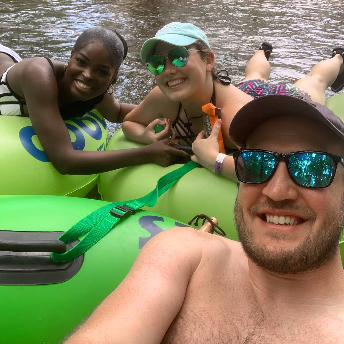 A caucasian man (front), a caucasian woman (middle) and an African American woman (left) tube down the Chatacooche River.