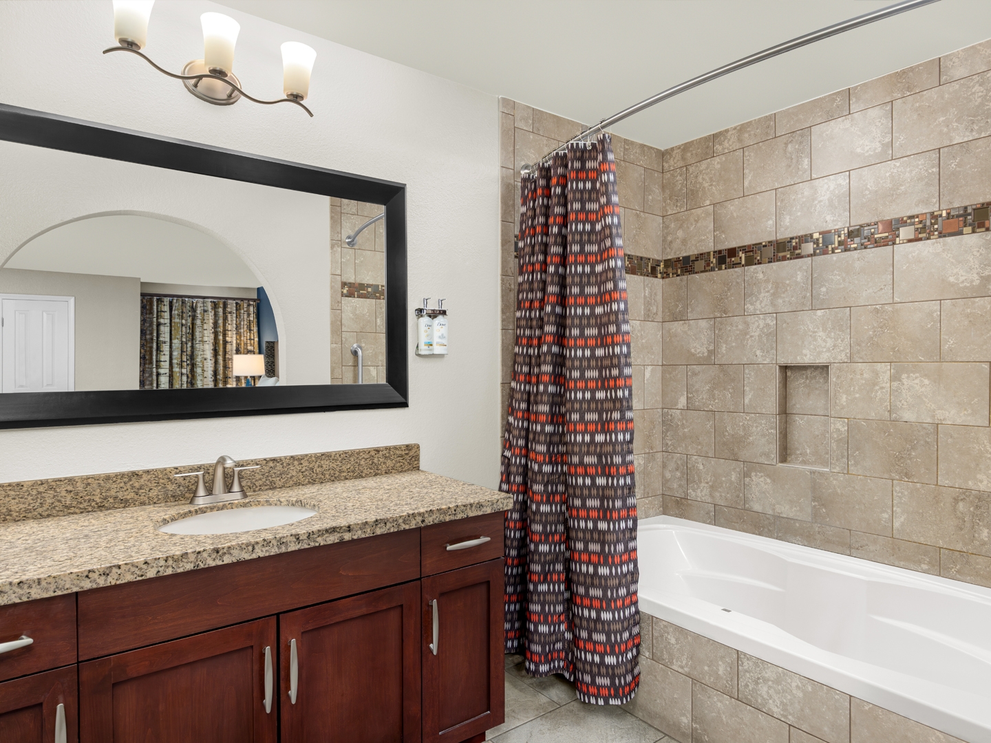 Modern bathroom with a granite vanity and tiled shower.
