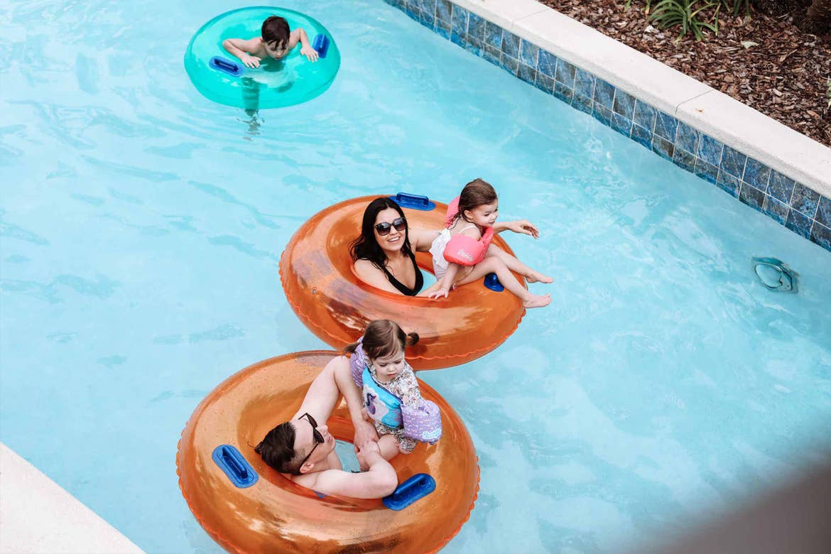Featured contributor, Mia St. Clair (top), and her family float along the lazy river in orange inner tubes.