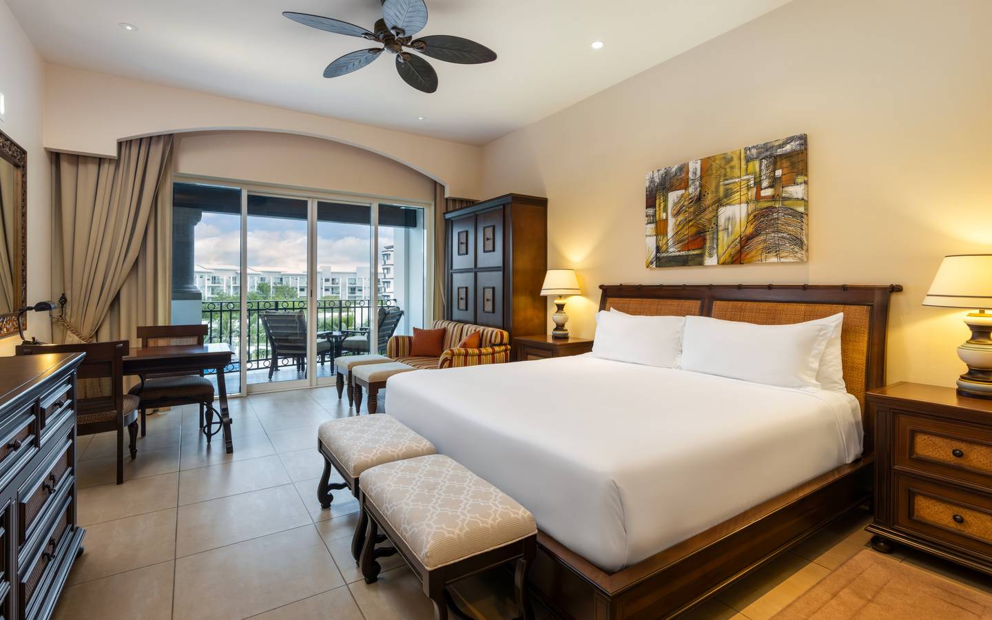 Master suite bedroom with king bed, balcony, and sitting area.