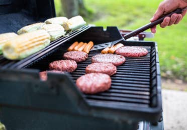 Person grilling corn, hotdogs and hamburgers at Villages Resort in Flint, Texas.
