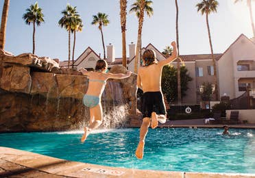 Two kids jumping into outdoor pool at Desert Club Resort in Las Vegas, Nevada