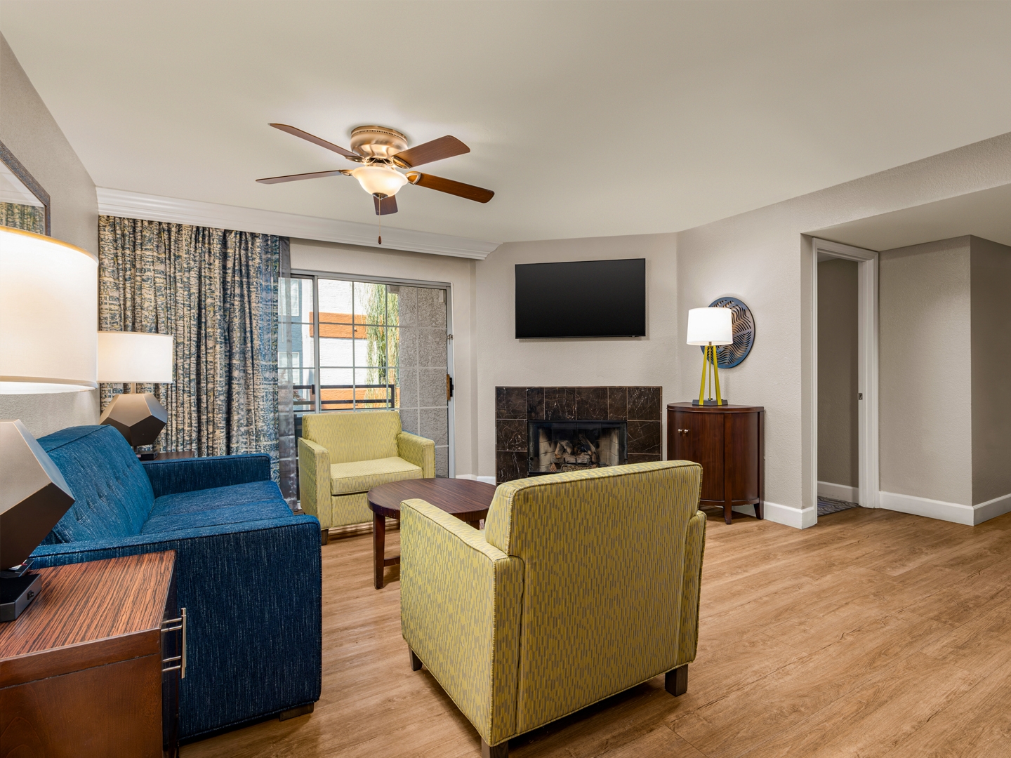 Spacious living area with sofa, dining table, and open kitchen.
