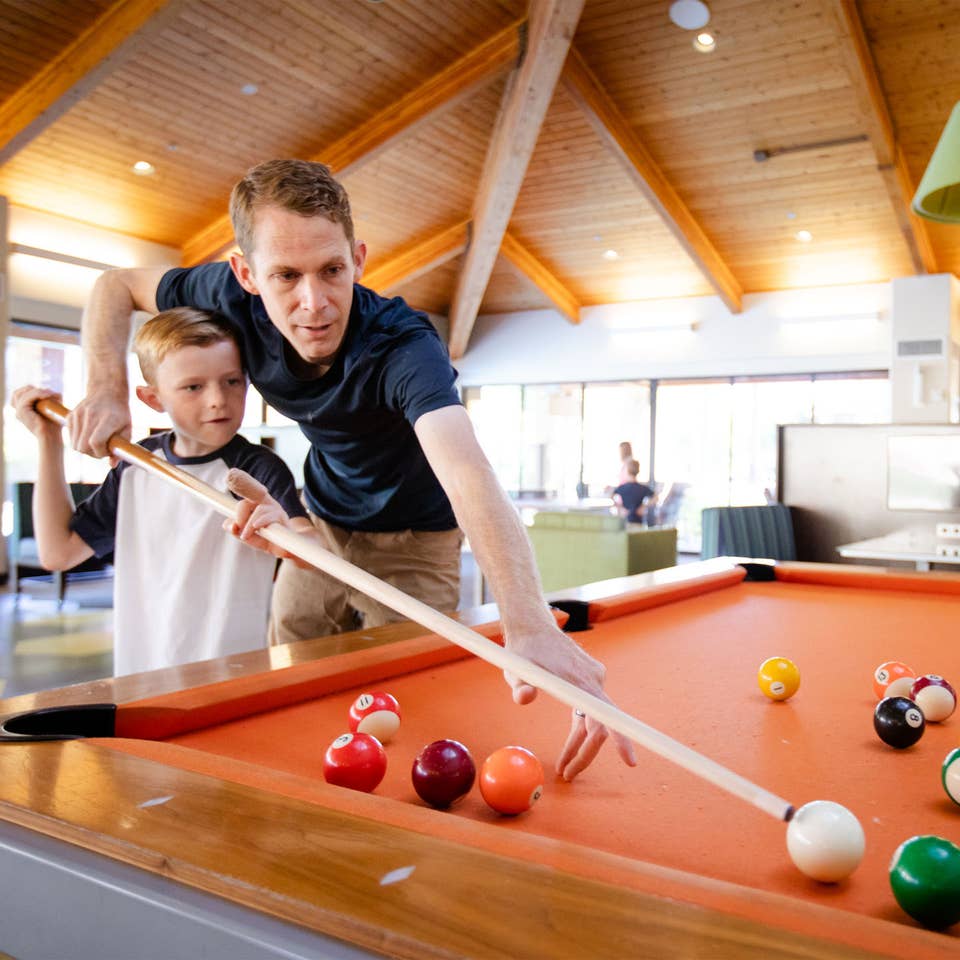 Adult and young child playing billiards at Scottsdale Resort in Scottsdale, Arizona.