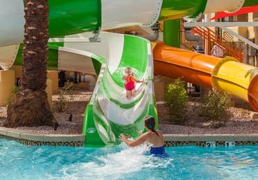 Young girl sliding down a water slide into the pool at Scottsdale Resort in Arizona.