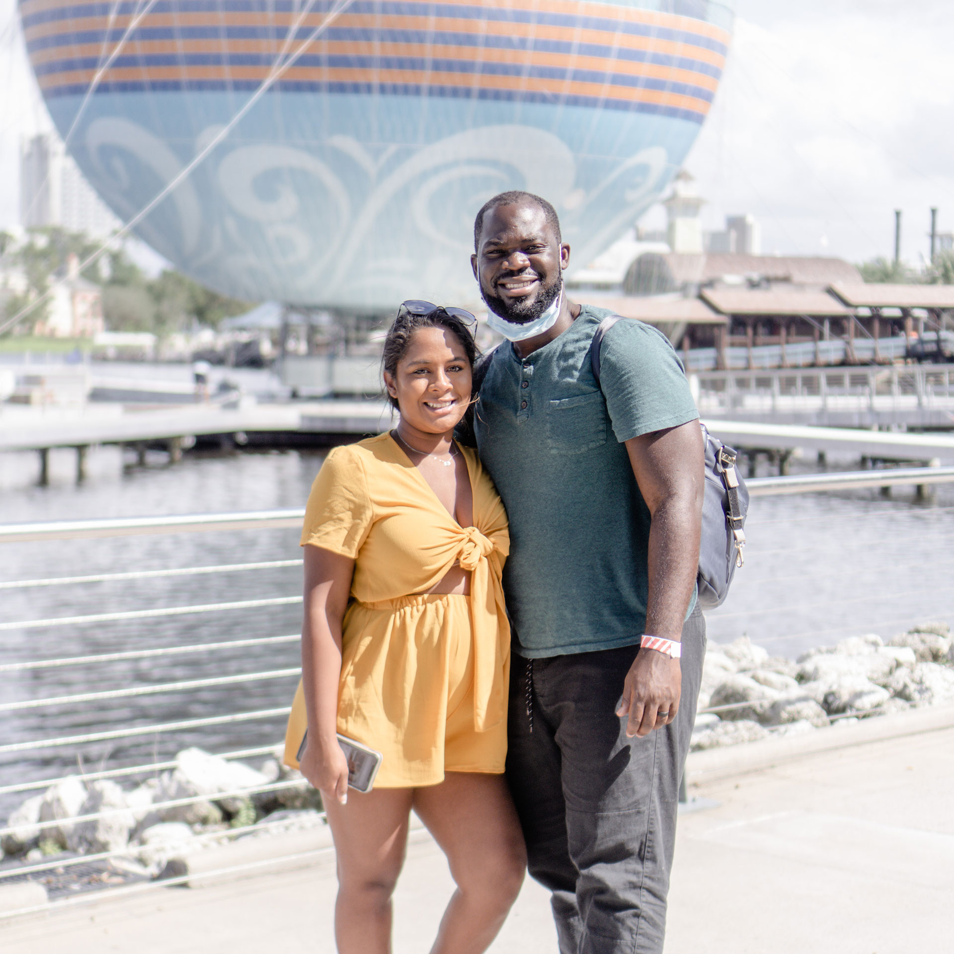 Author, Kimberly Gelin (left), poses with her husband in front of the 'Aerophile – The World Leader in Balloon Flight' at Disney Springs in Walt Disney World Resort.