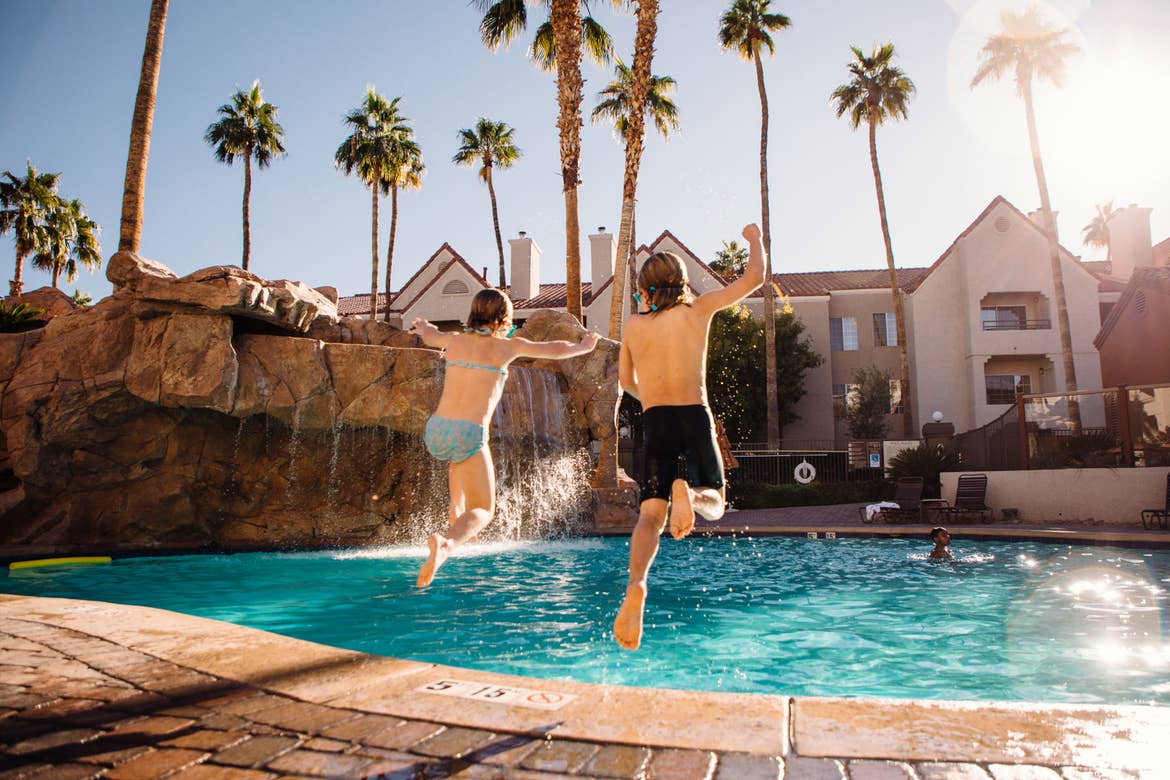 The Haby kids jump into one of the heated pools of our Desert Club Resort located in Las Vegas, Nevada wearing swimsuits and goggles.