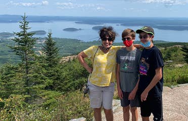 Author, Jennifer Probst (left), and her sons (middle and right) stand on the edge of the Acadia National Park hiking trail while wearing their masks.