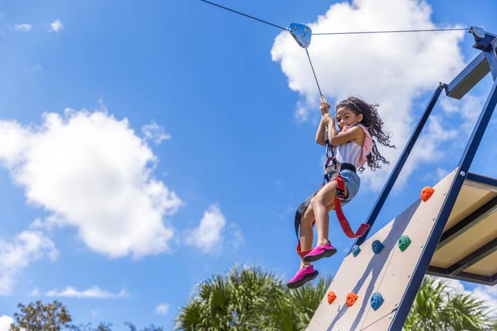 Young girl riding the Zipline at the Fun Zone at Orange Lake Resort in Orlando, FL