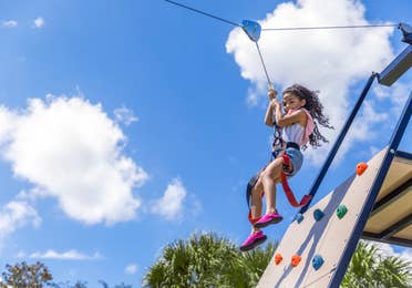 Young girl riding the Zipline at the Fun Zone at Orange Lake Resort in Orlando, FL