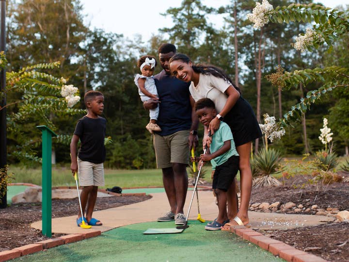 Family playing mini-golf.