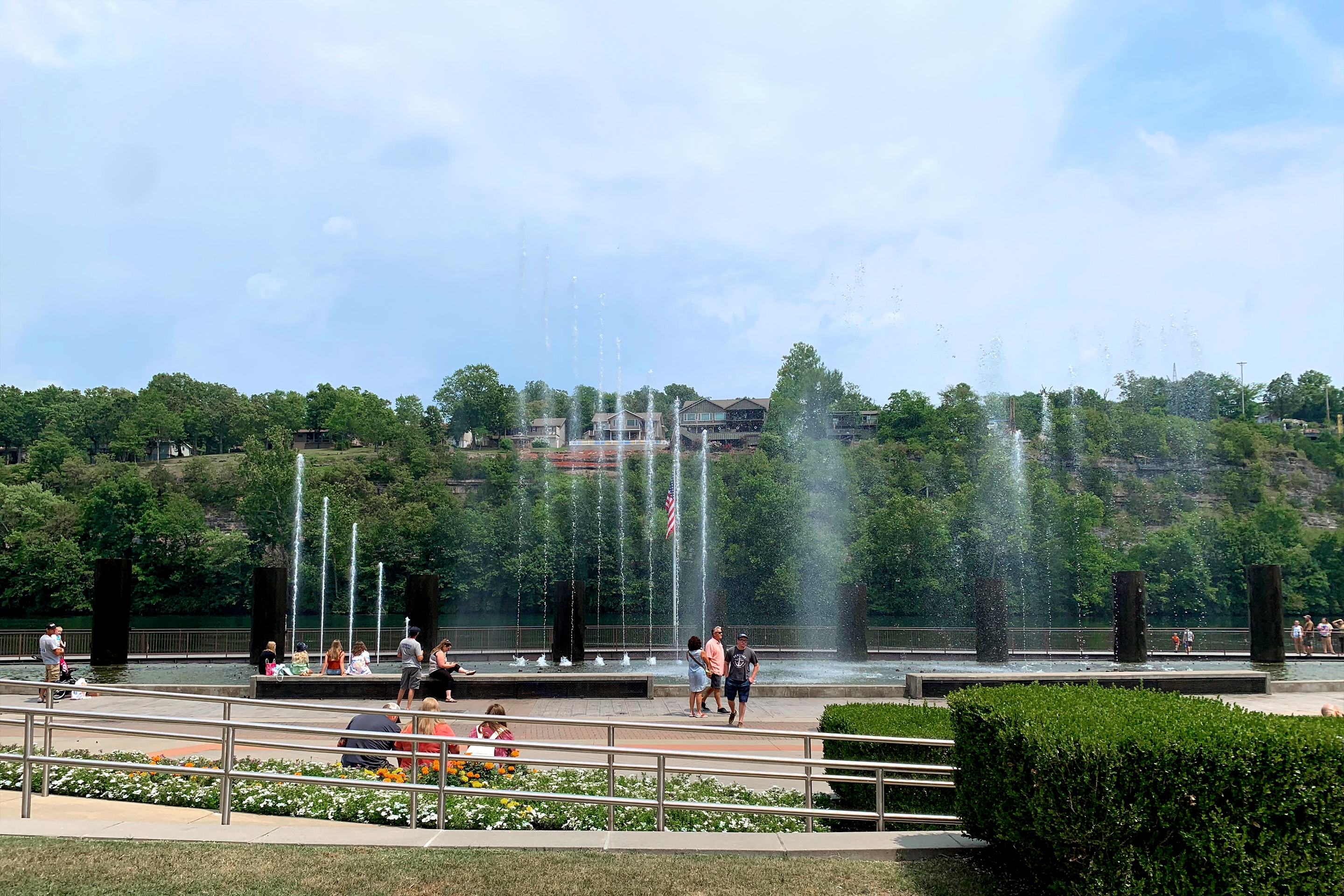 An outdoor water feature displays high fountains with guests looking from below.