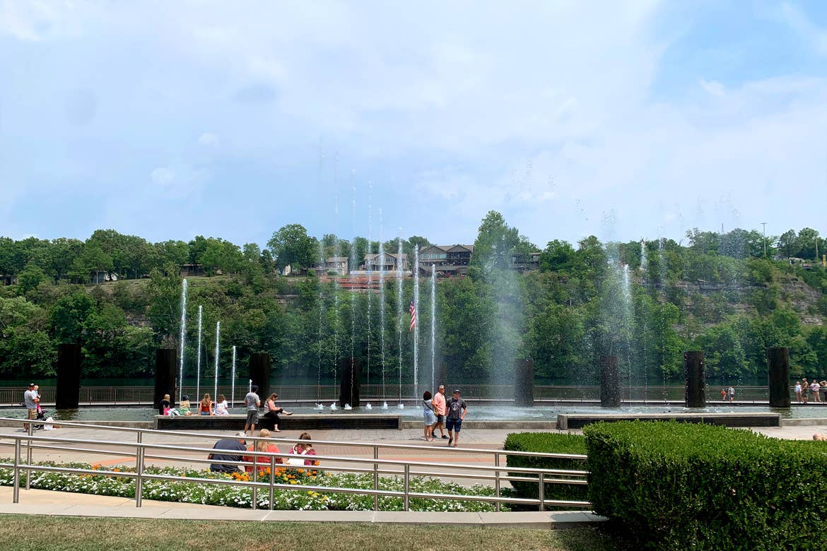 An outdoor water feature displays high fountains with guests looking from below.