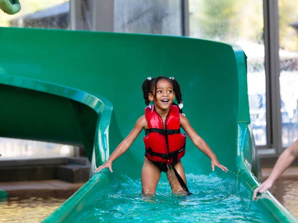Small child coming out of waterslide at The Waterpark at The Villages at Villages Resort in Flint, Texas.