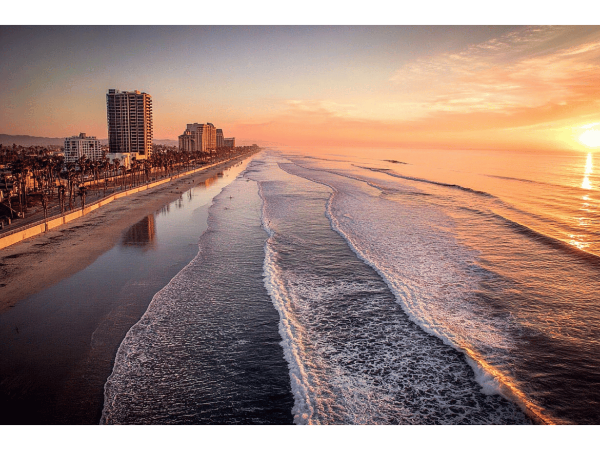 Pink sunset over San Diego shoreline, with waves splashing onto shore