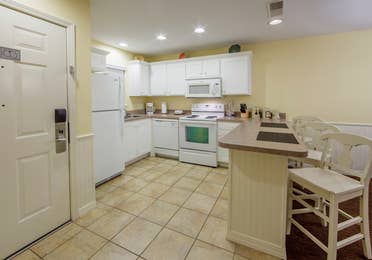 Kitchen with fridge, dishwasher, oven, microwave, and sink in a Presidential two-bedroom villa at Ozark Mountain Resort in Kimberling City, Missouri