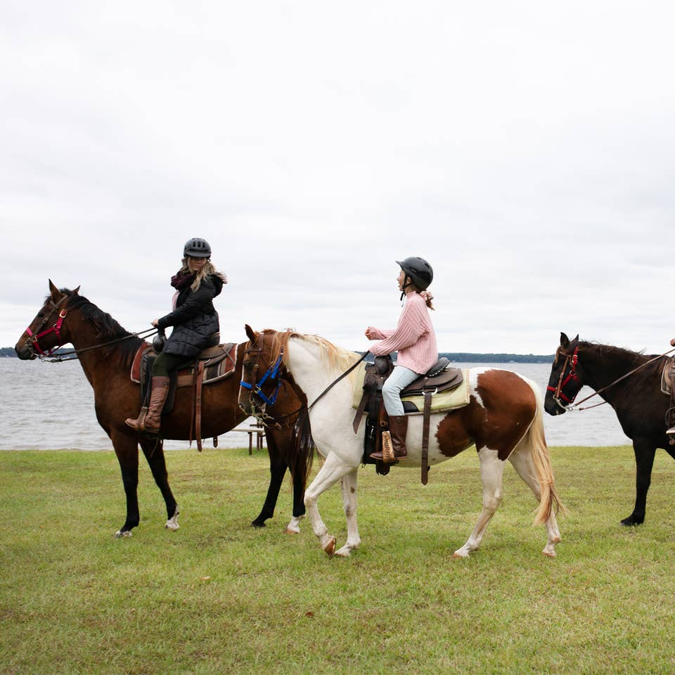 Group of three people riding horses at Villages Resort in Flint, Texas.