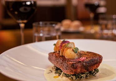 At the Los Murales, a dinner plate with blackened fish on top of creamed greens, topped with sauteed onions and potatoes at the Royal Haciendas, Playa del Carmen, Mexico