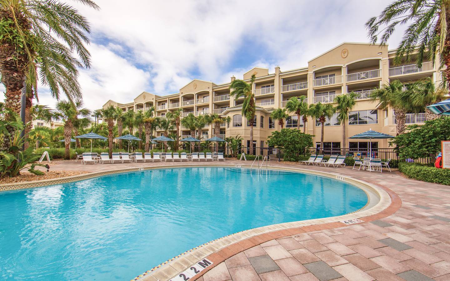 Outdoor pool surrounded by palm trees at Cape Canaveral Beach Resort