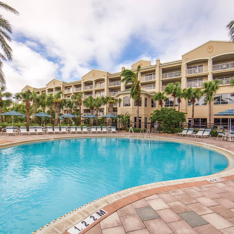 Outdoor pool surrounded by palm trees at Cape Canaveral Beach Resort