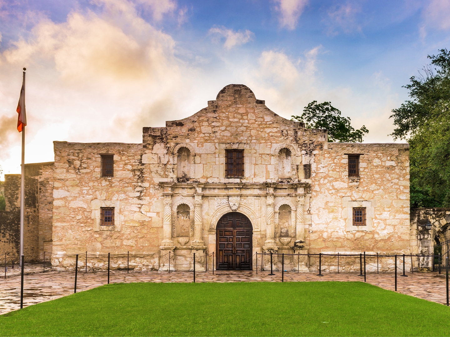 The Alamo in San Antonio, Texas underneath a blue, cloudy sunset sky.