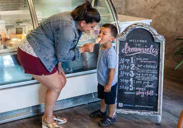 Mother feeding child ice cream at Branson Strip near Holiday Hills Resort.