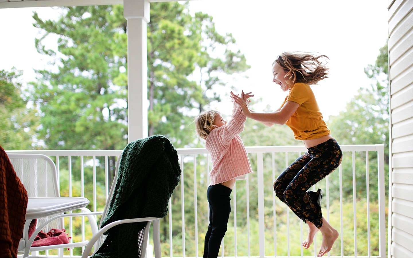 A mother and daughter dancing on a balcony at a resort