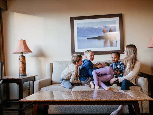 Mom and three children sitting on couch in a villa at Tahoe Ridge Resort in Stateline, Nevada.