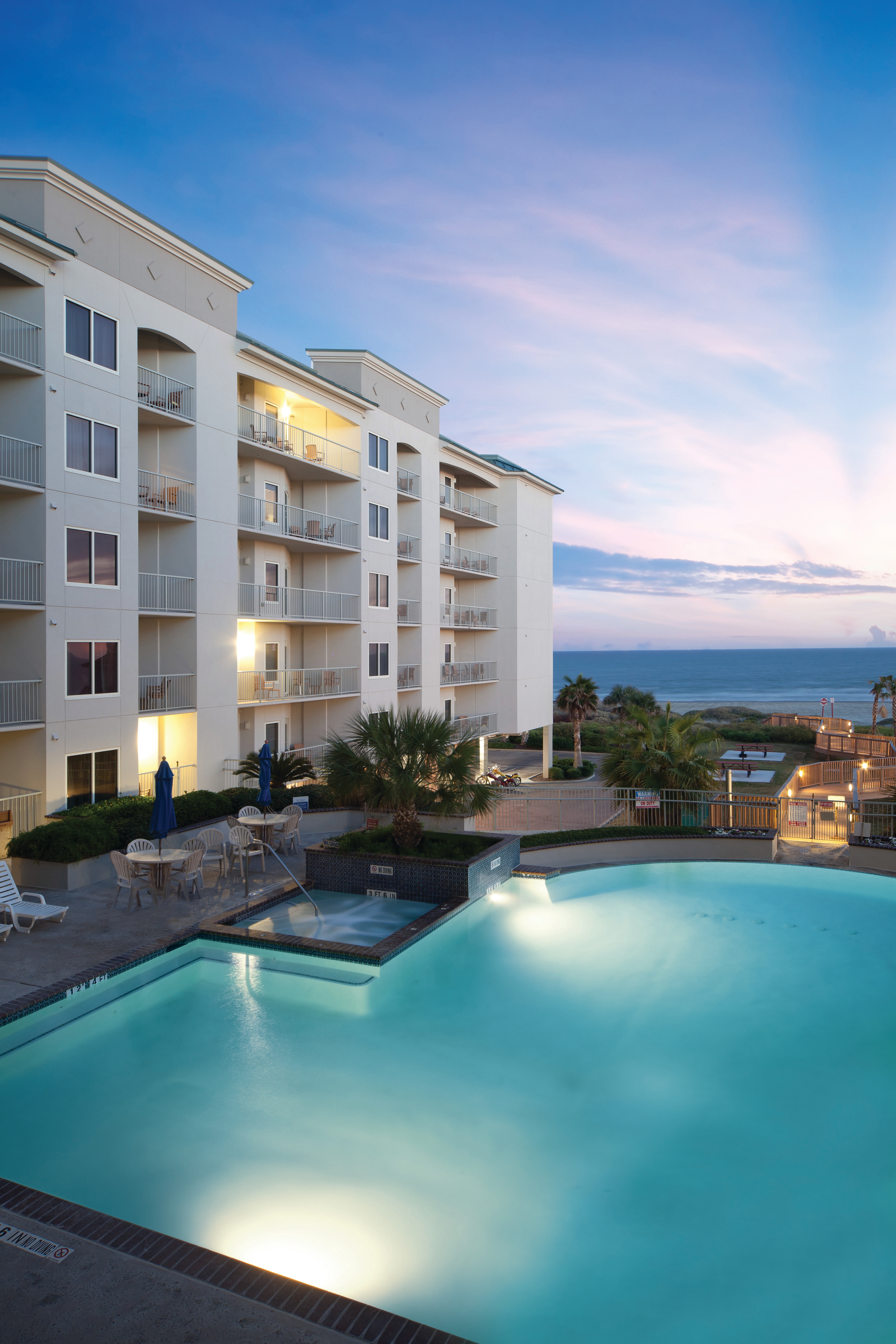 Resort outdoor pool with umbrellas and beach chairs at Galveston Beach Resort.