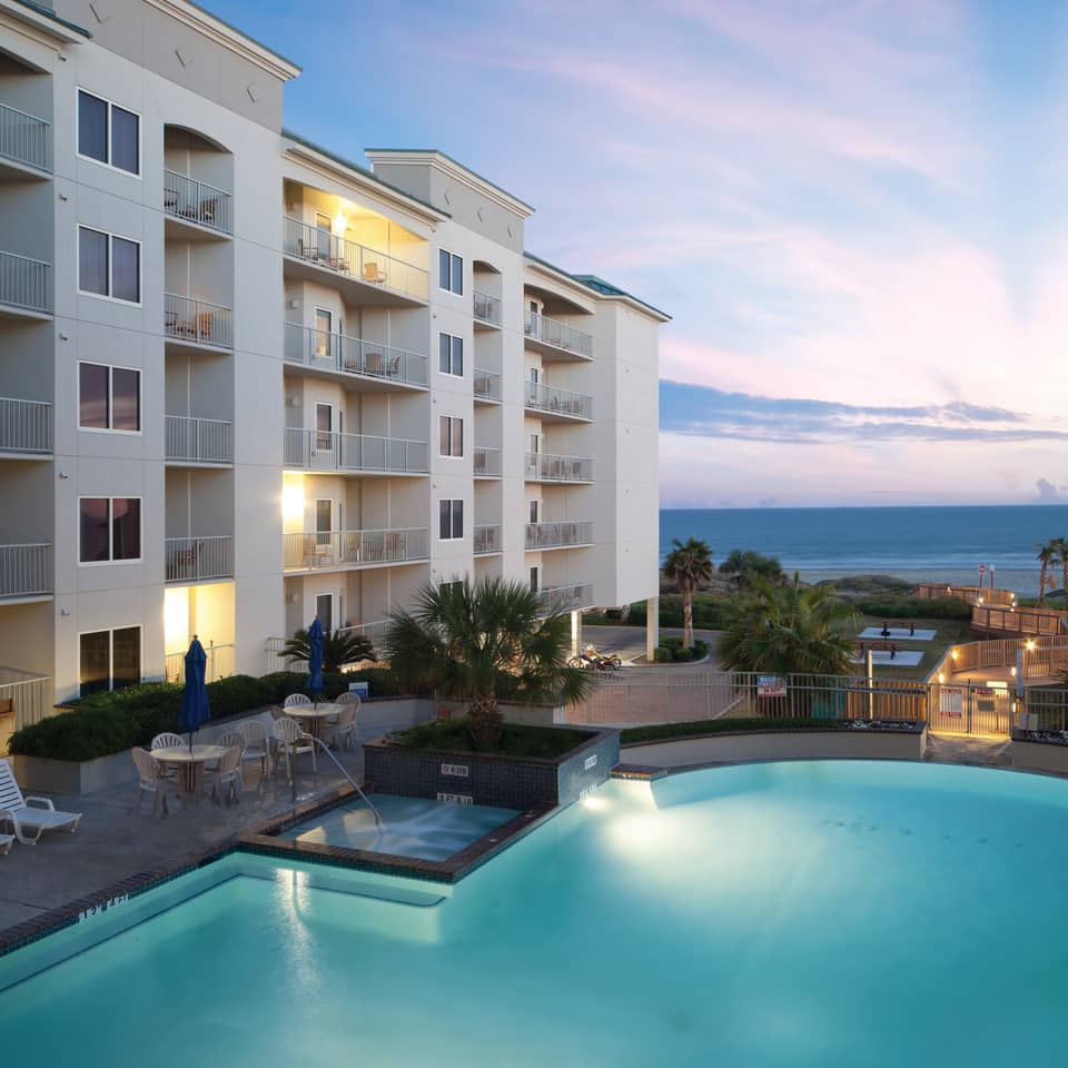 Resort outdoor pool with umbrellas and beach chairs at Galveston Beach Resort.