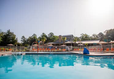 Outdoor springcreek pool surrounded by red pool chairs at Villages Resort in Flint, Texas