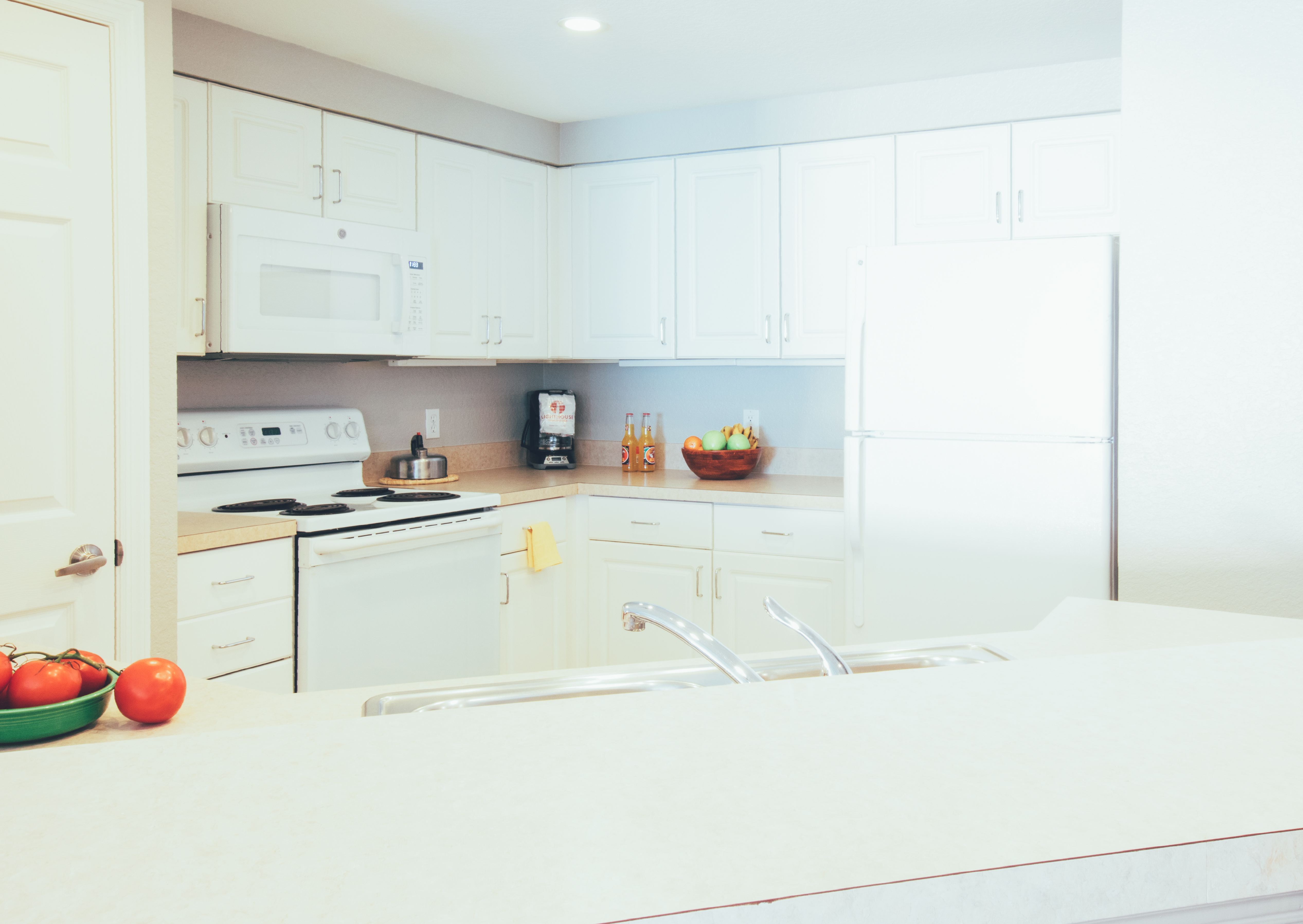 Full kitchen with fridge, oven, microwave, and sink in a villa in River Island at Orange Lake Resort near Orlando, Florida