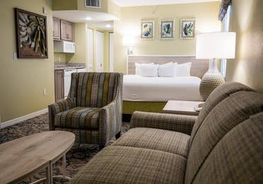 Couch, chairs, kitchenette and a bed in a villa at Cape Canaveral Beach Resort.