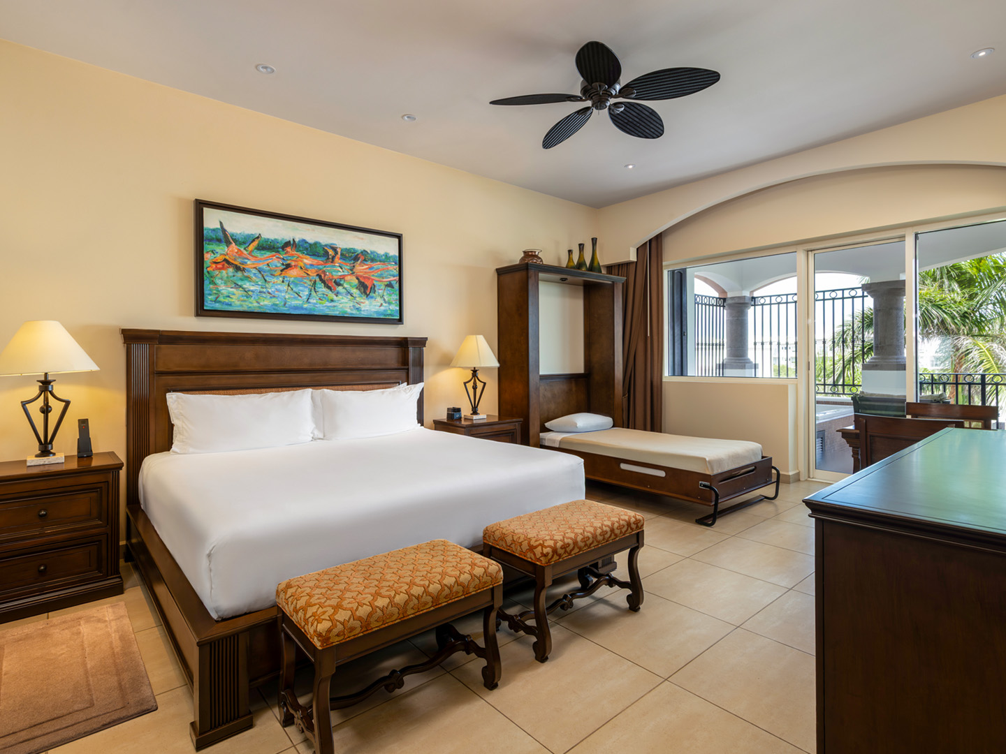 Spacious master bedroom with king bed, daybed, and balcony.