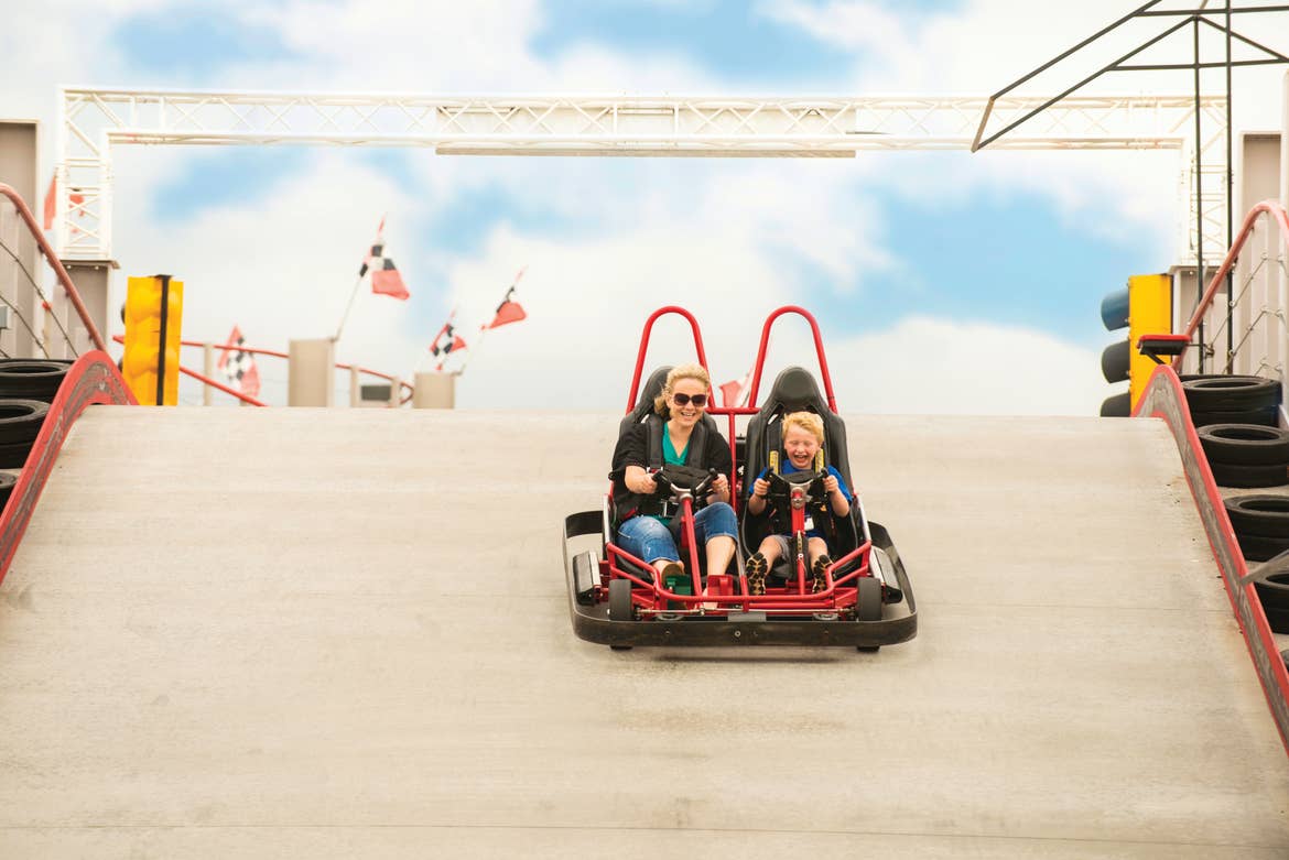 A woman and child ride a go-kart on an outdoor track at Silver Dollar City.