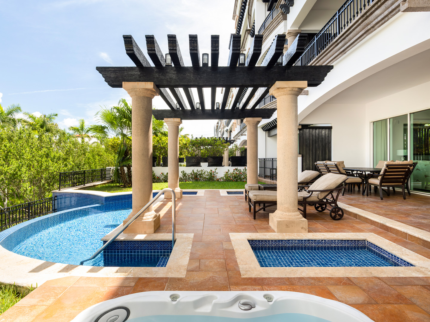 Private terrace with plunge pools, loungers, and shaded pergola.
