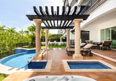 Private terrace with plunge pools, loungers, and shaded pergola.