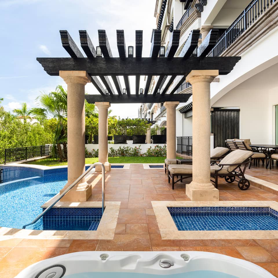 Private terrace with plunge pools, loungers, and shaded pergola.