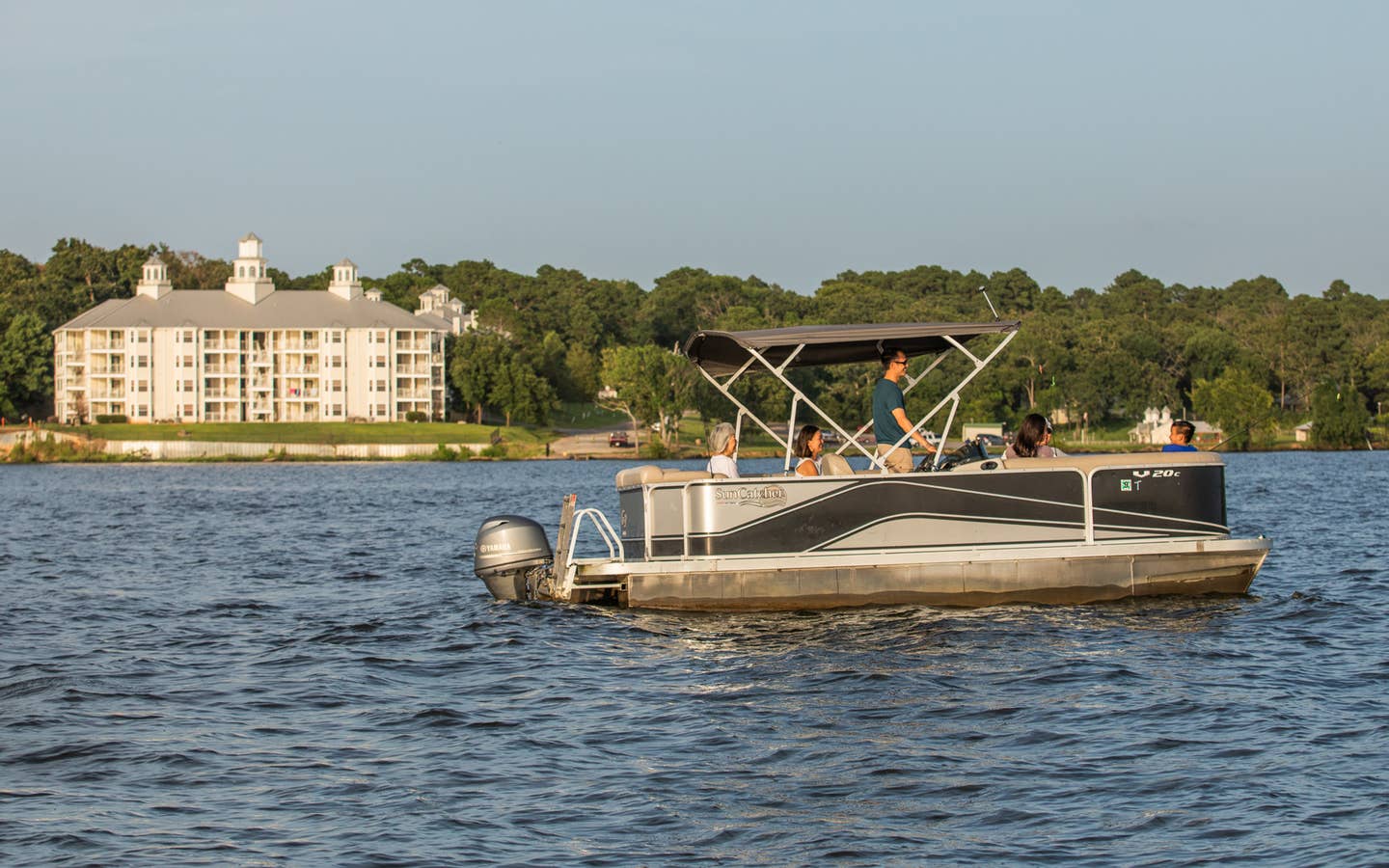 Family riding on pontoon boat at Villages Resort in Flint, Texas.