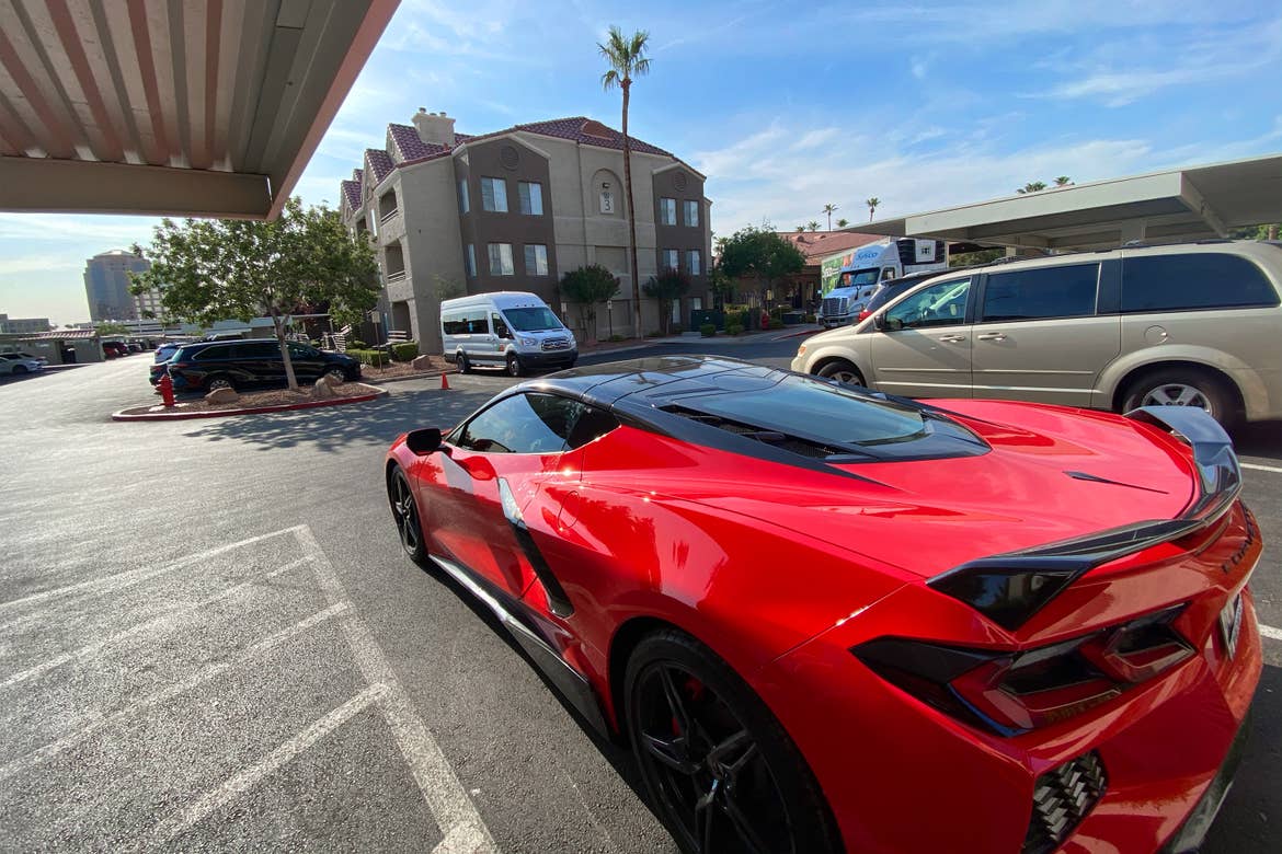 A red Corvette parked outdoor in the parking lot of our Desert Club Resort.